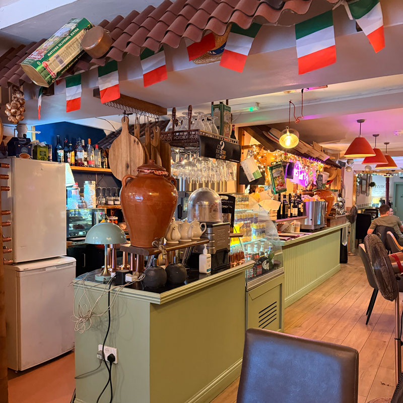 Inside Amici Ristorante Italiano in Ashford — cosy Italian bistro with white tablecloths and burgundy decor
