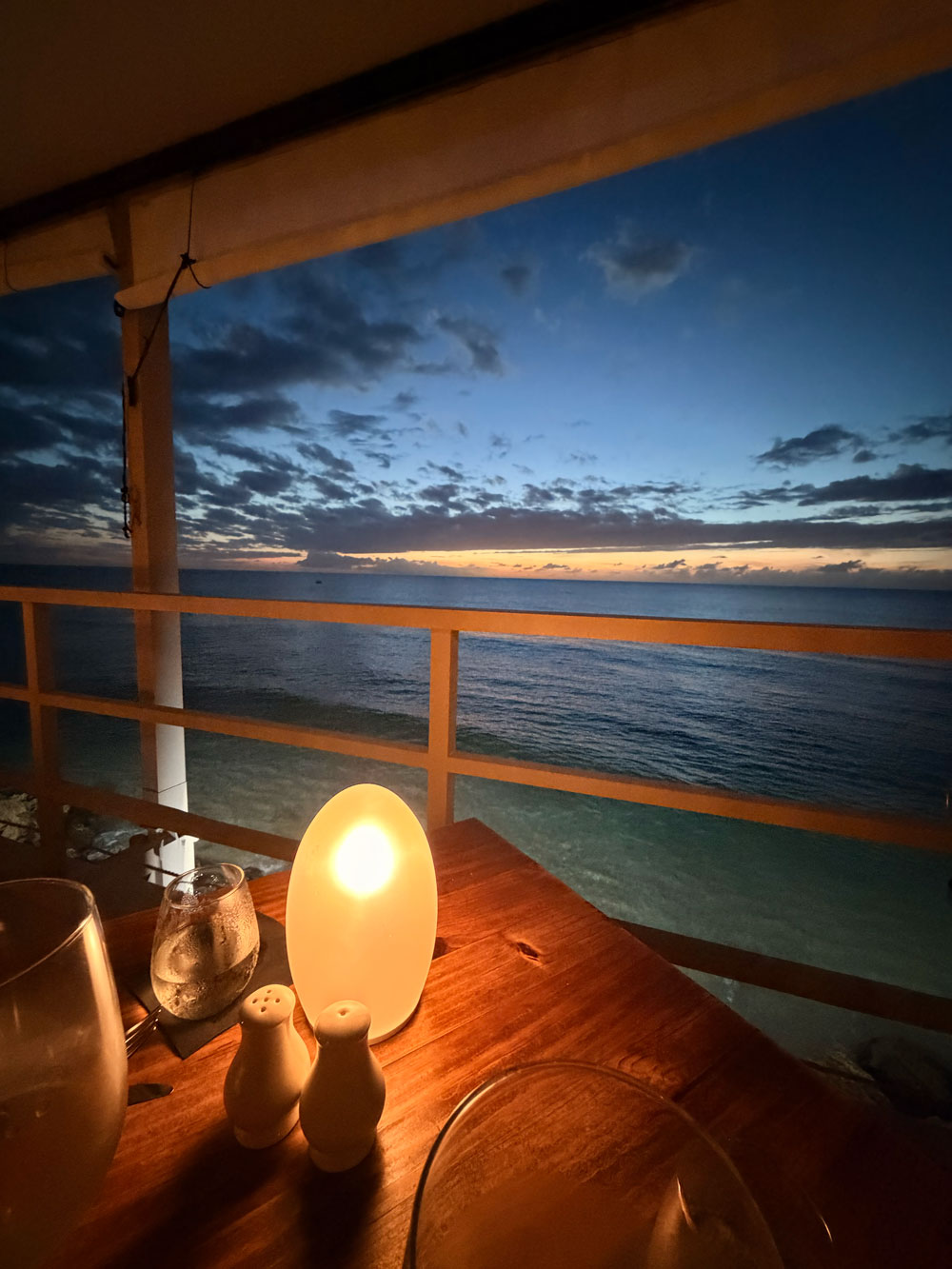 A candlelit table looking out to a Caribbean sunset