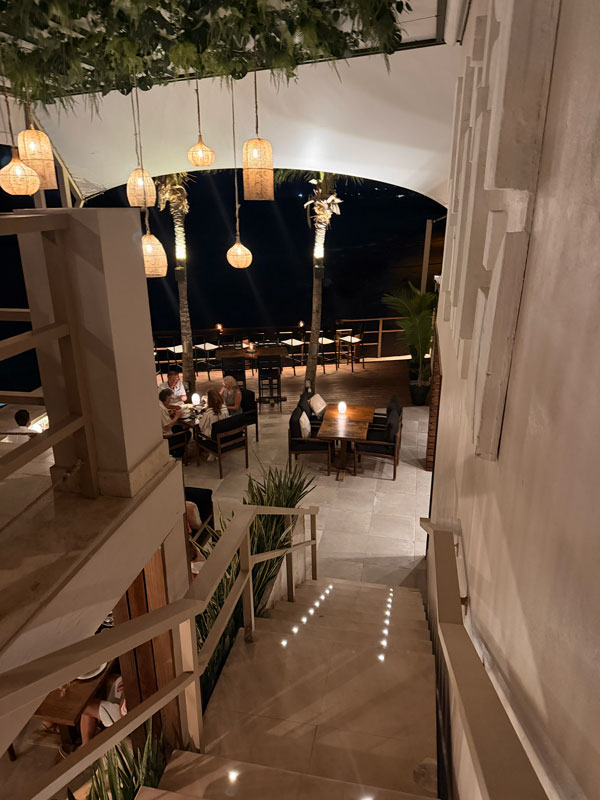 Baia Barbados restaurant interior with open coastal views and ambient lighting at sunset