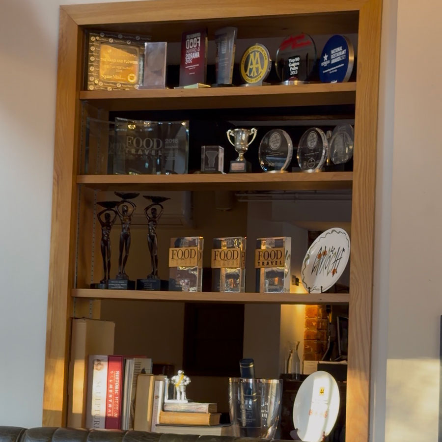 Tom Kerridge's awards and accolades displayed on a shelf at The Hand and Flowers, Marlow
