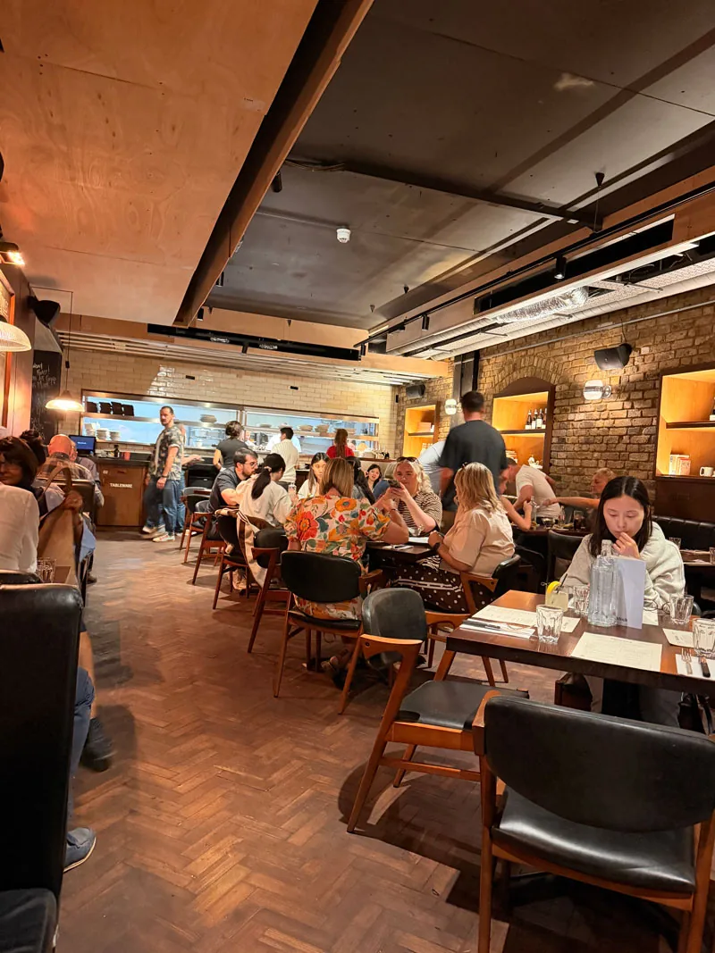 The Blacklock Covent Garden dining room, parquet floor, exposed London brick and a full room at the twelve o'clock Sunday sitting