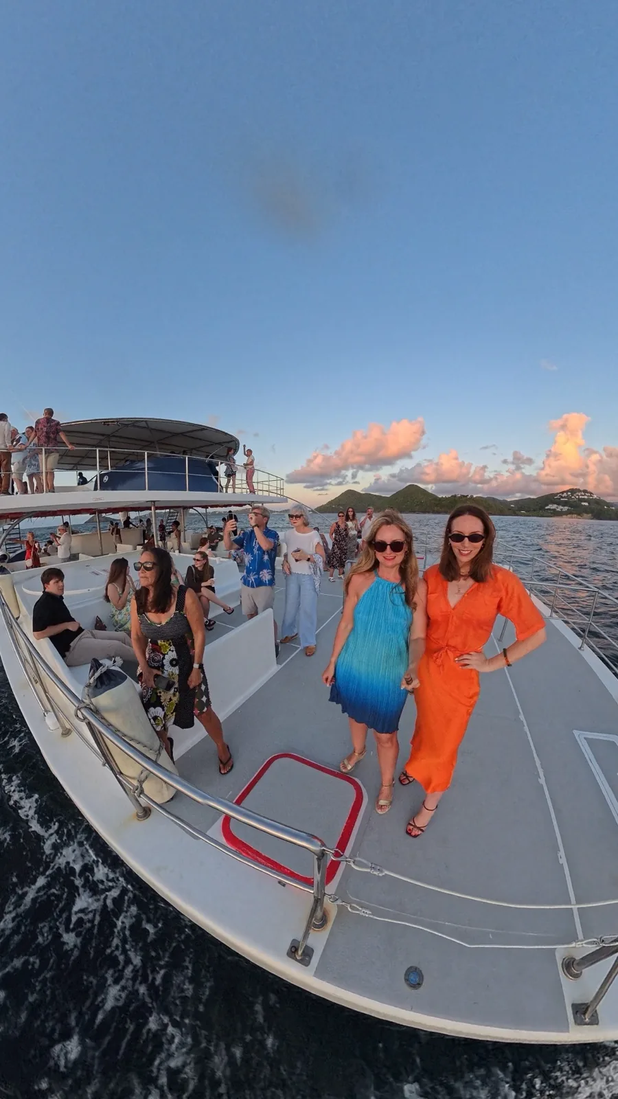 On the bow of a catamaran at sunset, heading up the coast