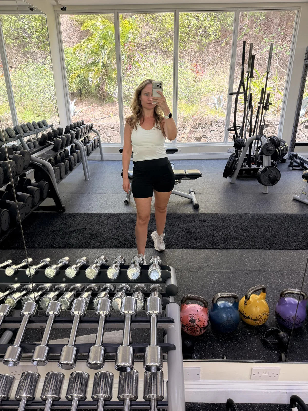 The gym at the BodyHoliday, with racks of free weights, kettlebells and garden windows