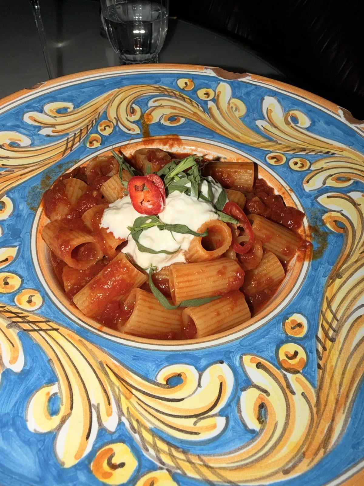 Pasta all'Arrabbiata, mezzi rigatoni with stracciatella and chilli, on a painted plate at Carlotta