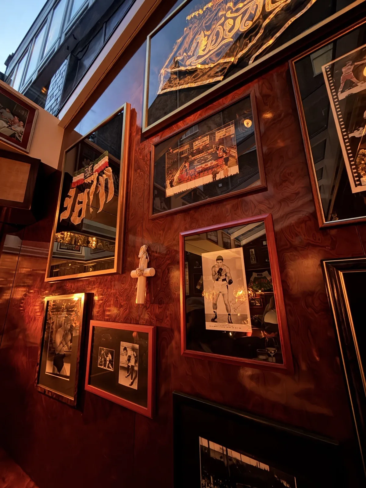 Framed vintage Italian boxing memorabilia crowding the walls at Carlotta