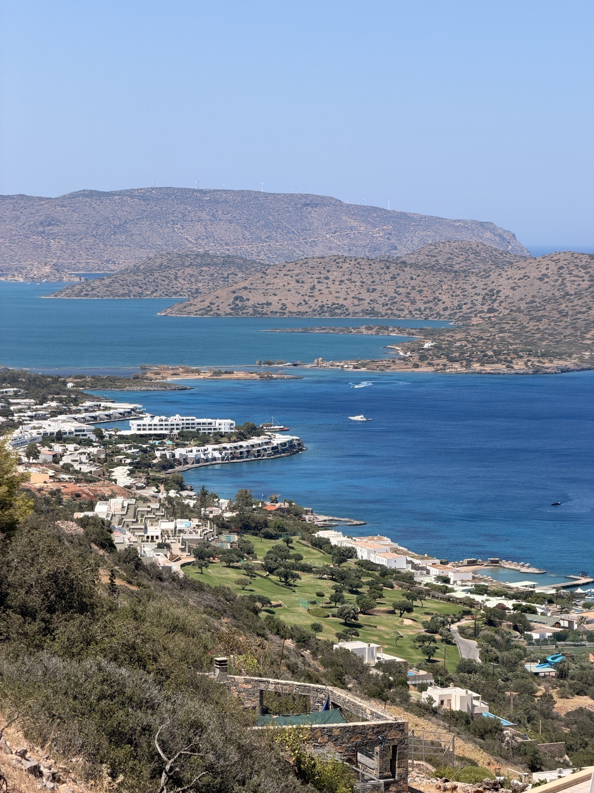 The Elounda coastline and olive groves, seen on a windy afternoon above the town