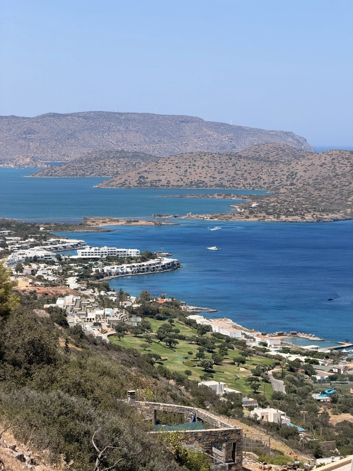 The Elounda coastline and olive groves, seen on a windy afternoon above the town