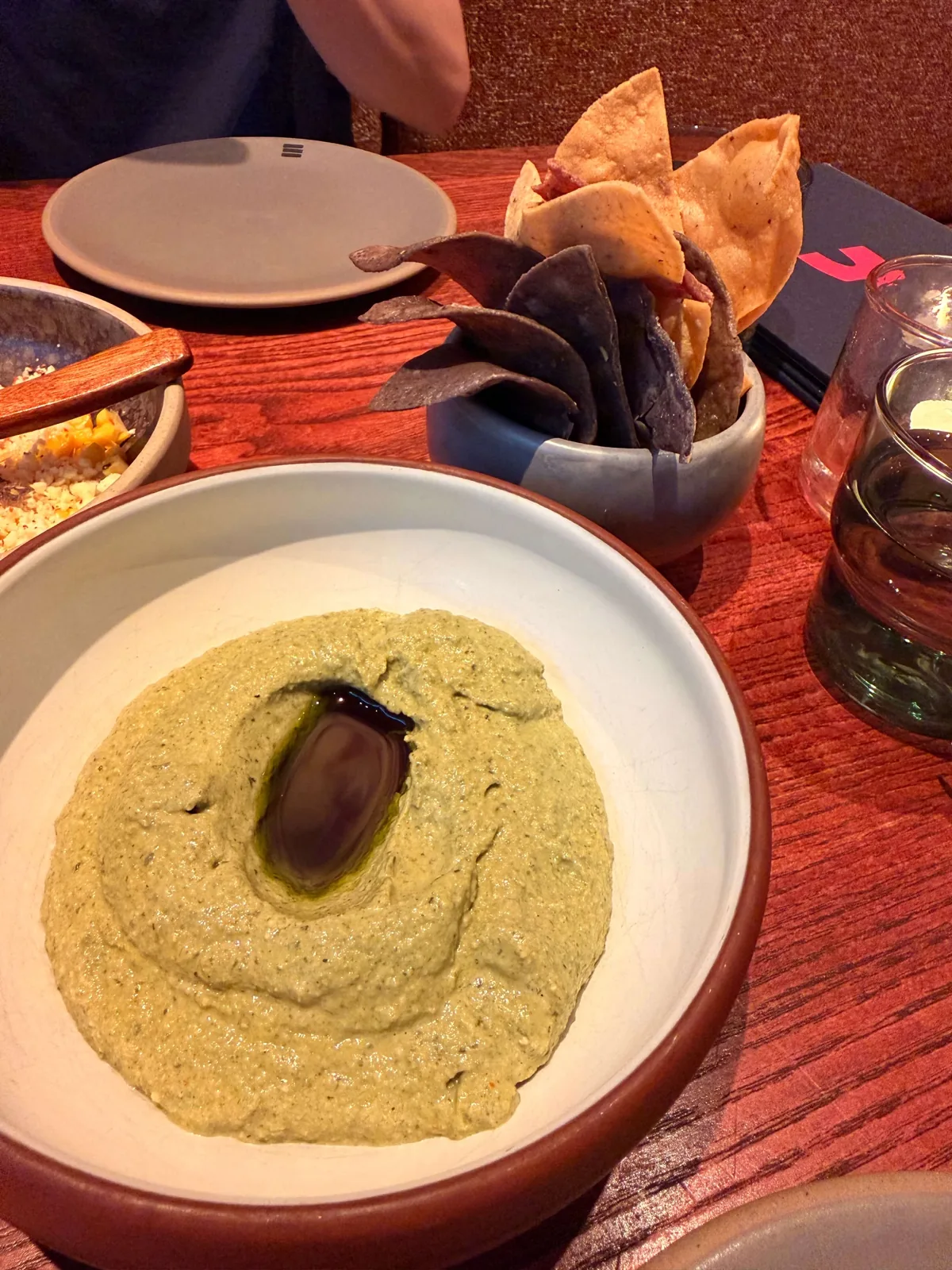 Roasted pumpkin seed mole at Fonda with a pool of oil in the middle, served with blue and yellow corn tortilla chips