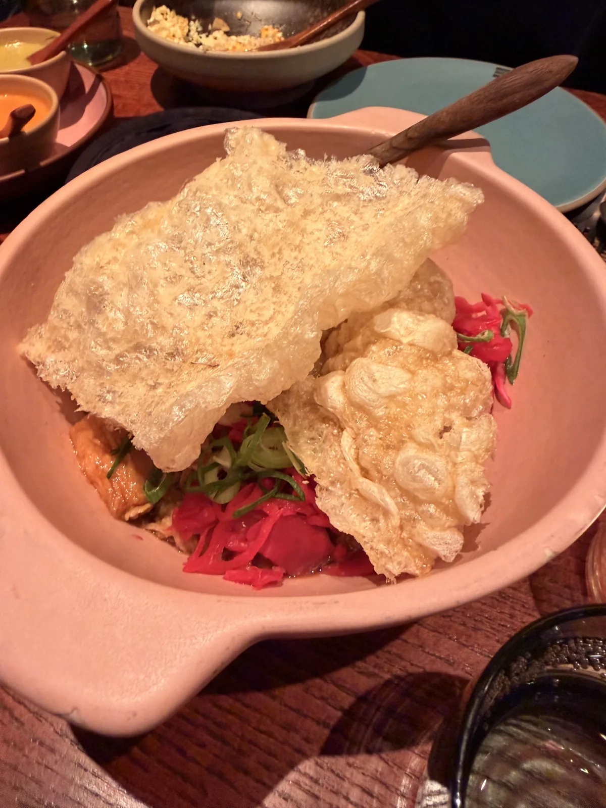 A sheet of crispy pork skin sitting on top of the pork shoulder carnitas at Fonda