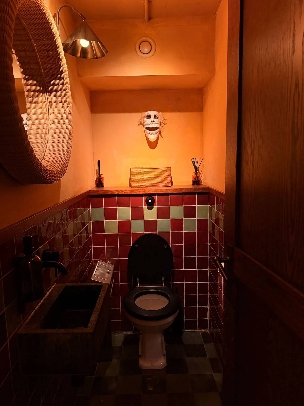 One of the individual unisex toilet cubicles downstairs at Fonda Mayfair, tiled in oxblood and cream