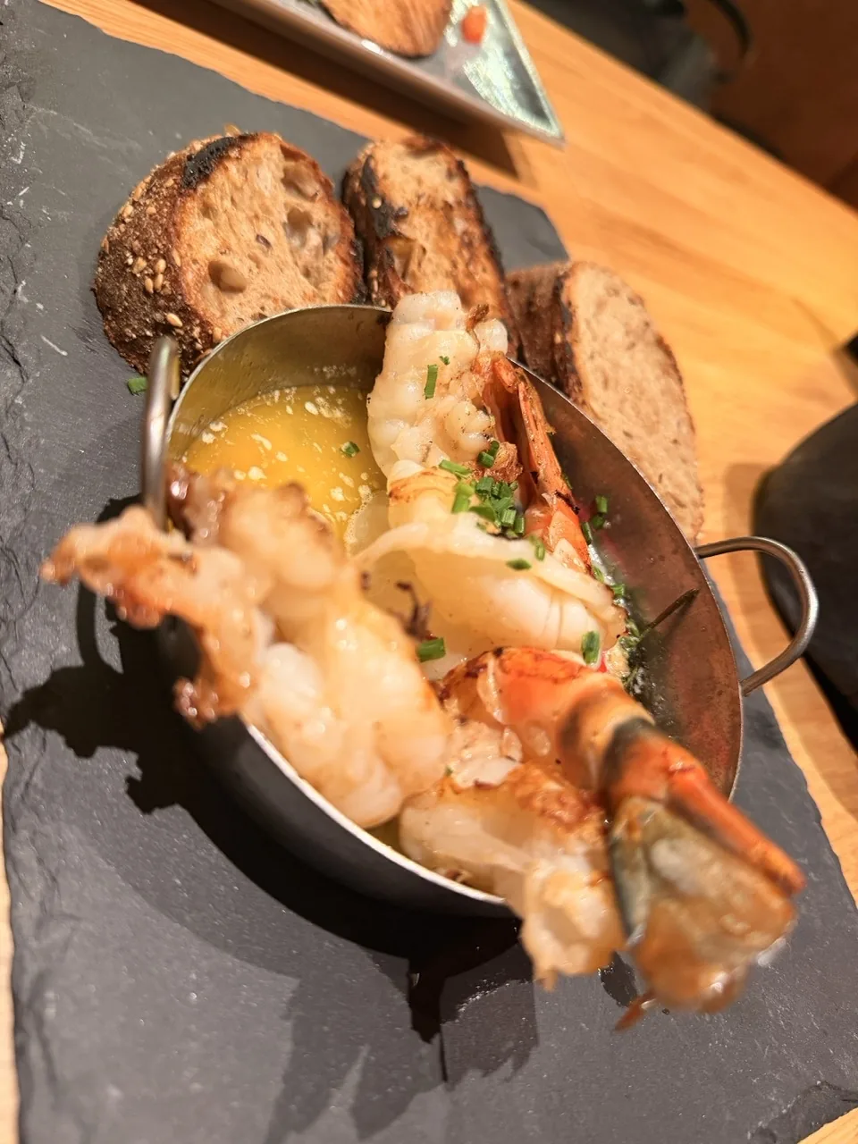 Prawns in garlic butter with toasted sourdough at a bar in Seefeld