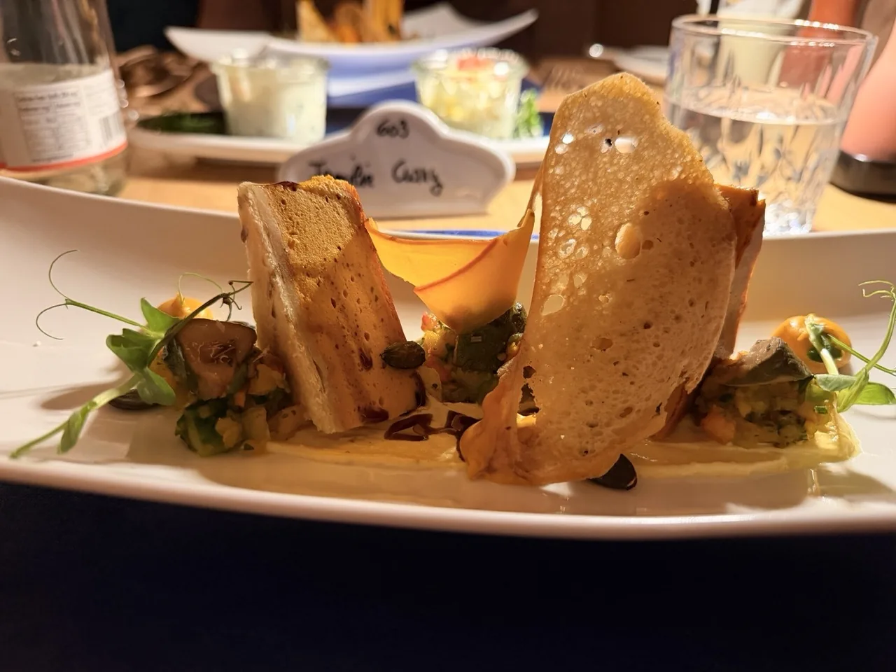 The first course of the Hotel Kristall Christmas Eve tasting menu, plated with wafers and micro herbs
