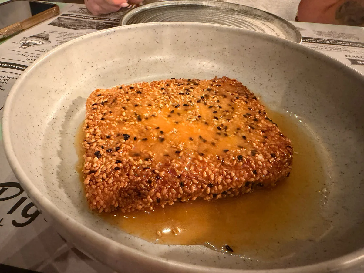 Fried feta saganaki with thyme honey and sesame seeds at Karnagio Agios Nikolaos, crisp at the edges and soft in the middle