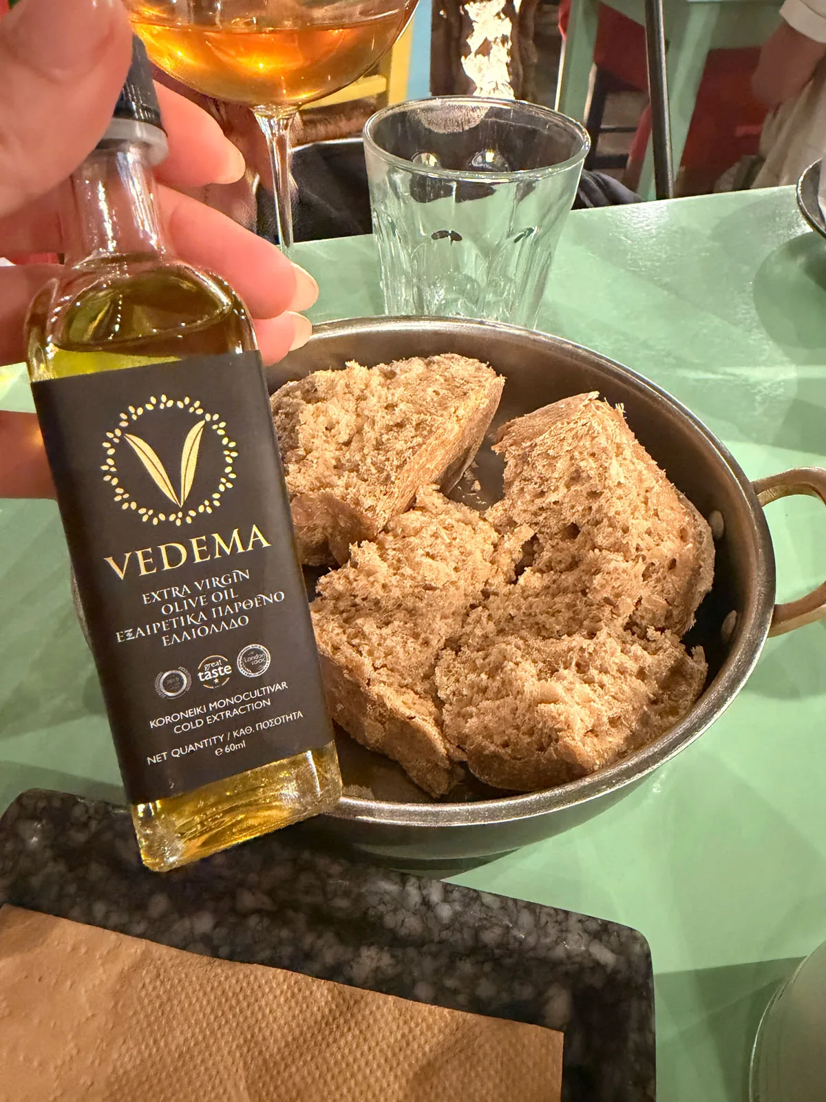 Vedema extra virgin olive oil beside a bowl of the manager's grandmother's sourdough at Karnagio
