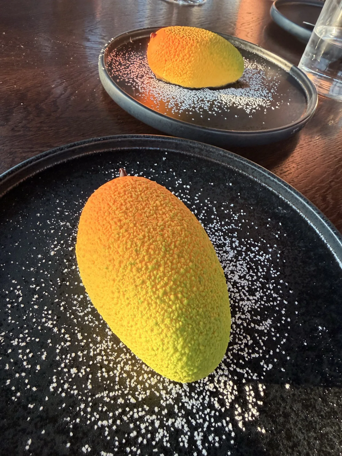 Mango and sake cheesecake with white chocolate and shiso, set inside a delicate hard shell, at Lucky Cat London