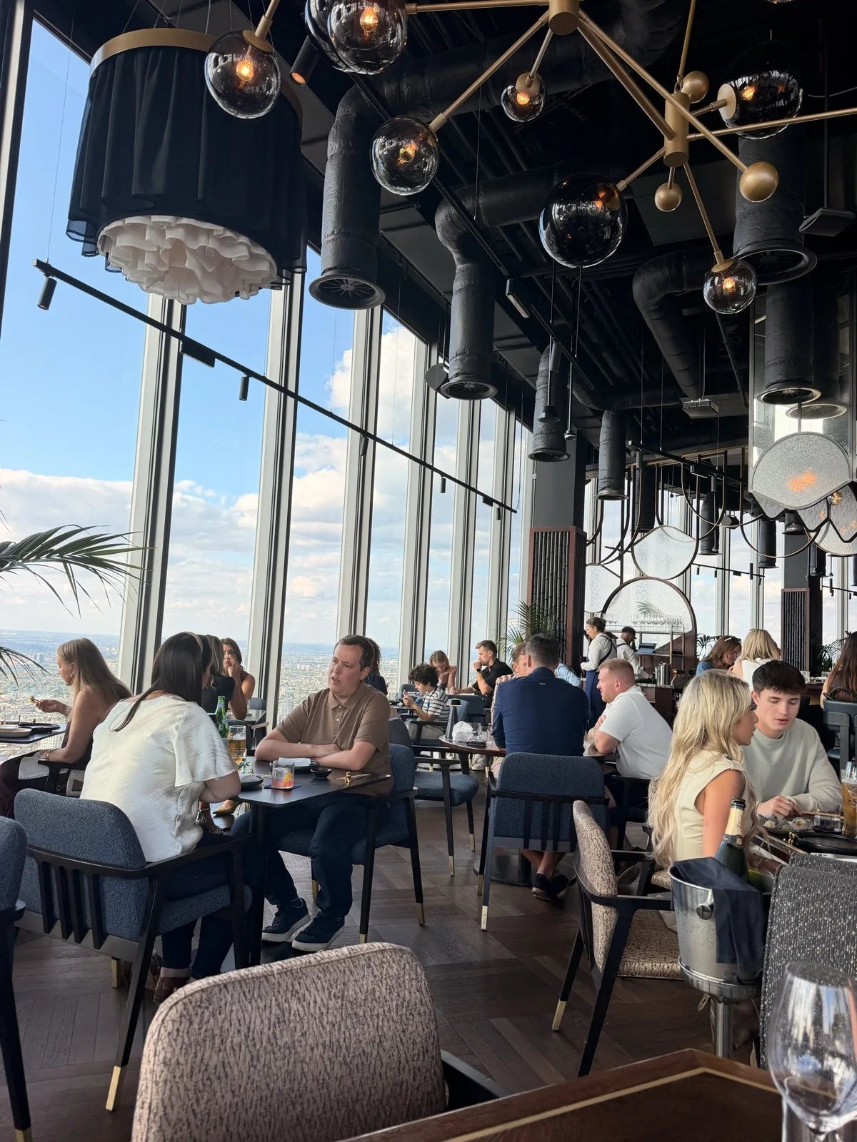 The Lucky Cat dining room on Level 60 of 22 Bishopsgate, with globe pendants hanging over the tables and London through the glass