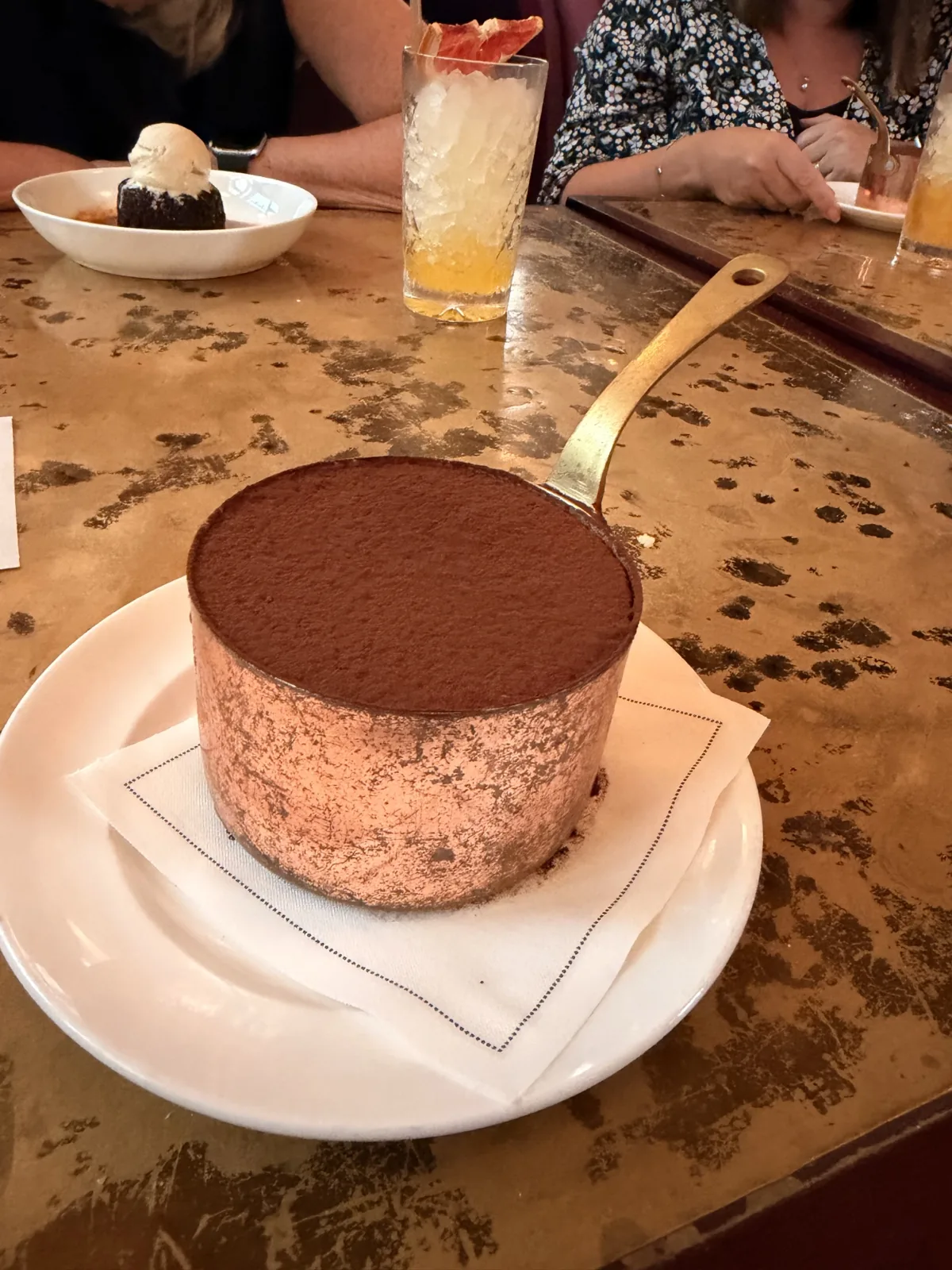 Millie's chocolate mousse served in a small copper saucepan, dusted thick with cocoa, on the gold leaf table