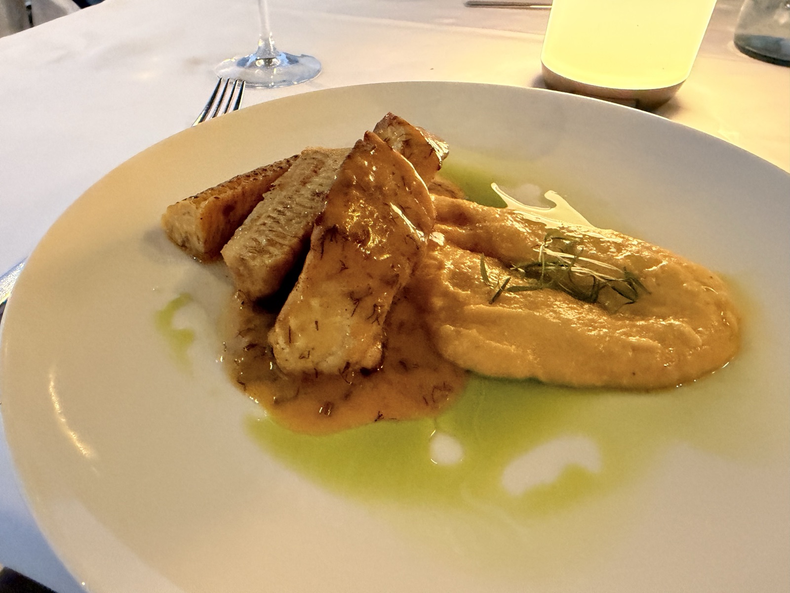 The fish main course at Mira Restaurant, NIKO Seaside Resort, plated with a smooth purée and dill oil