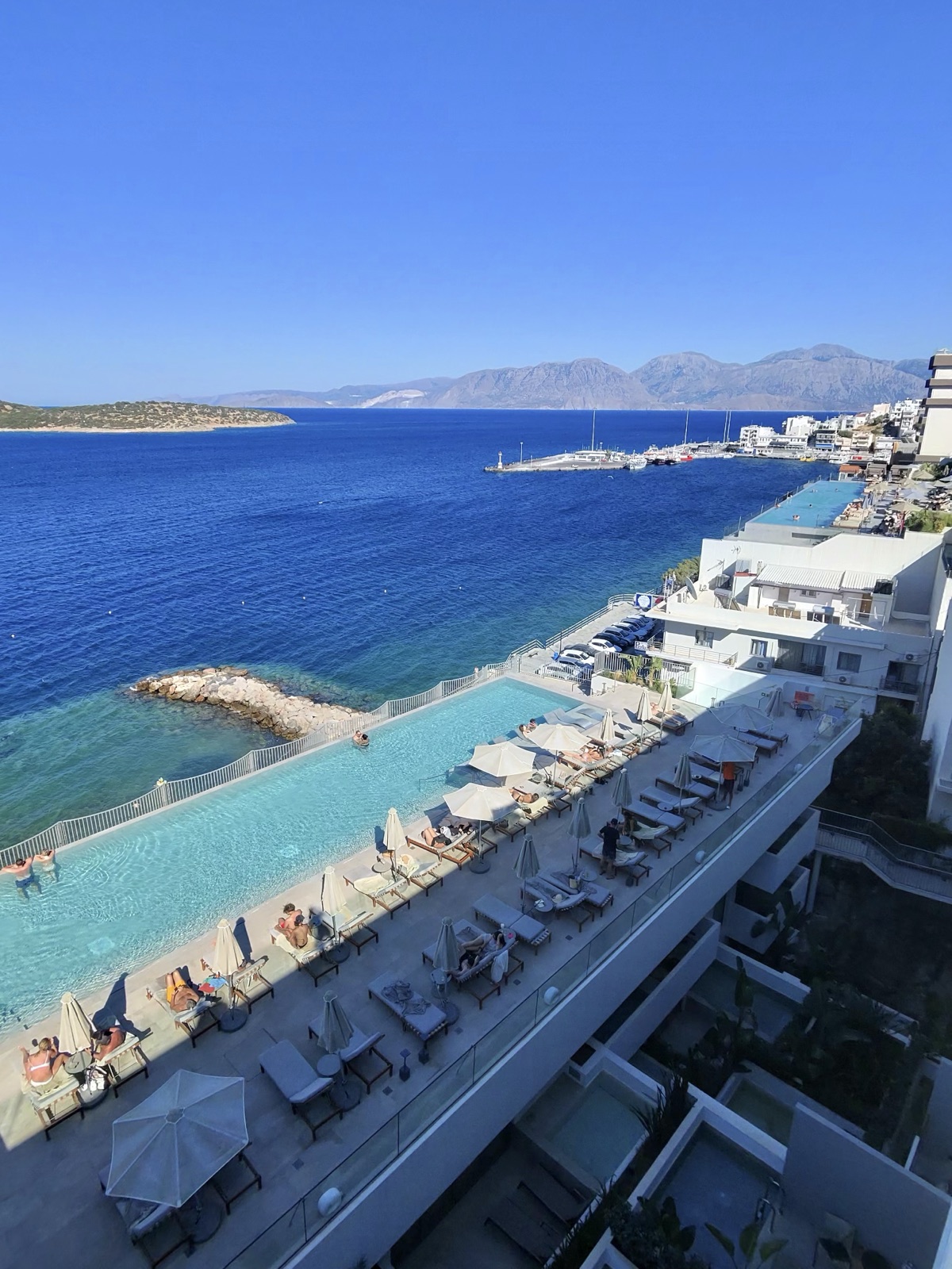 Looking down over the infinity pool terrace and Mirabello Bay from high up at NIKO Seaside Resort