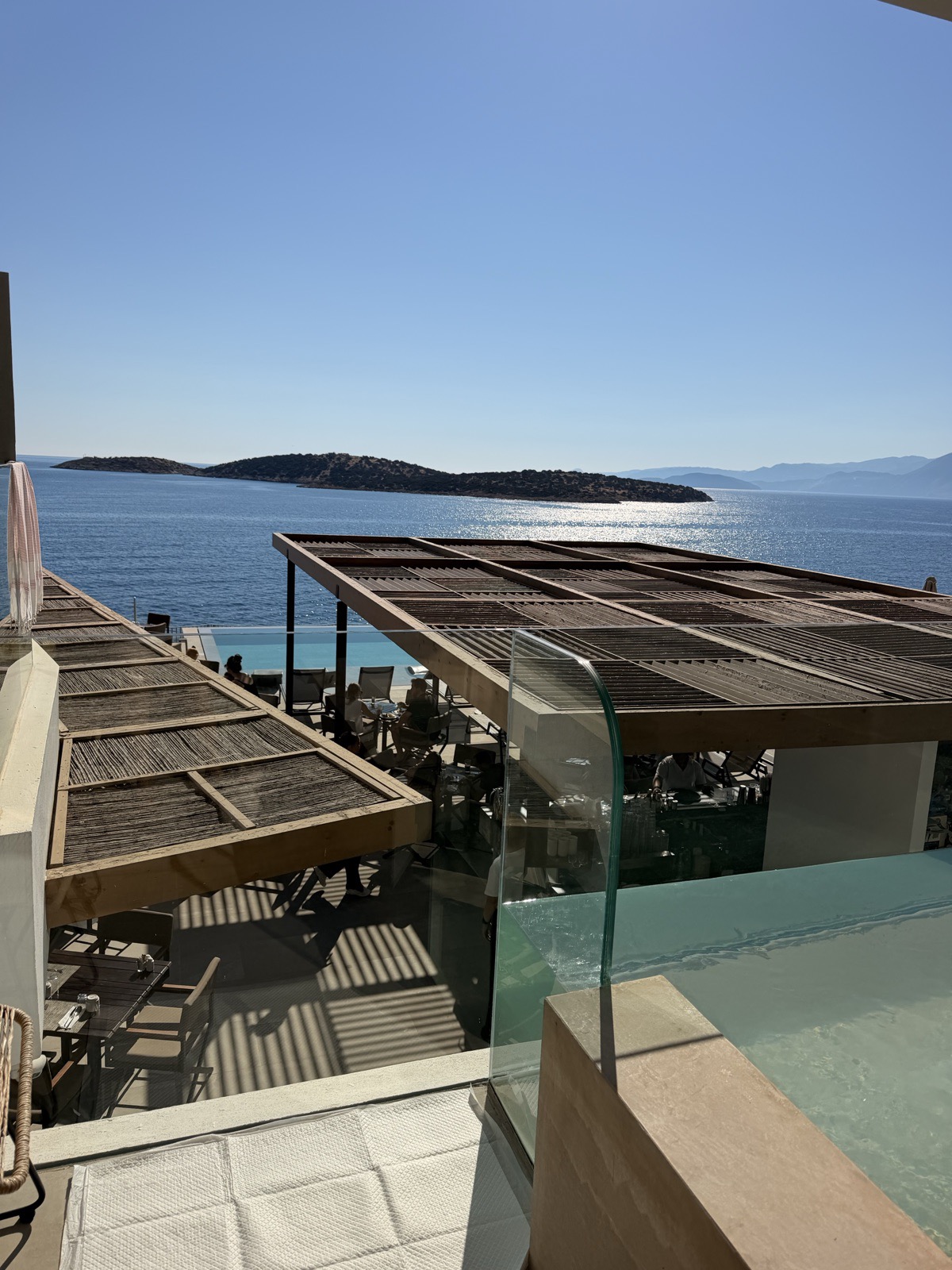 The view from the sixth floor balcony at NIKO Seaside Resort, looking down over the pool terrace to Mirabello Bay