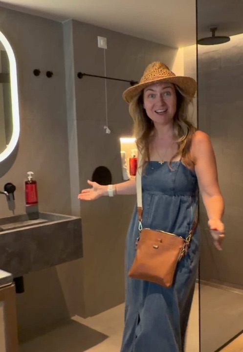 Room tour at NIKO Seaside Resort in Crete, showing the open plan bathroom with its stone basin and rain shower