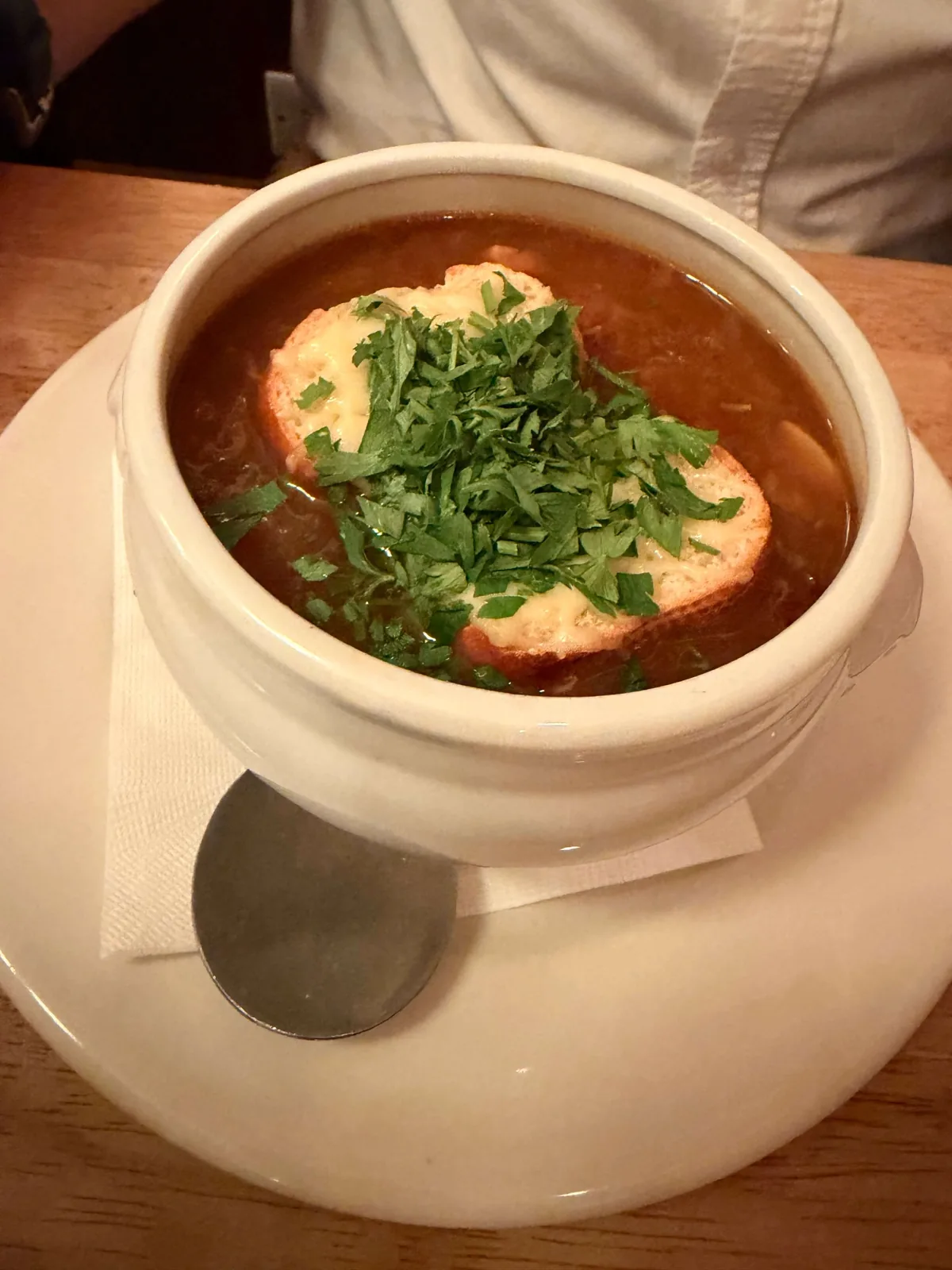 French onion soup with a thick gruyère crouton in a deep white bowl at Prix Fixe Brasserie, Soho