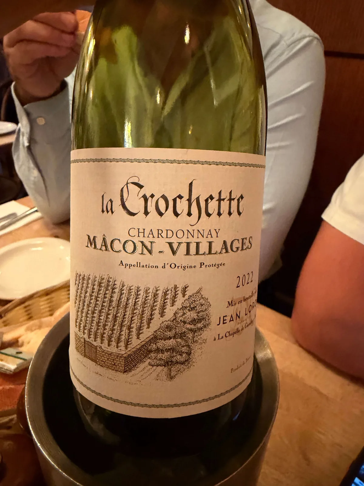 A bottle of La Crochette Chardonnay, Mâcon Villages 2022, on the table at Prix Fixe Brasserie Soho