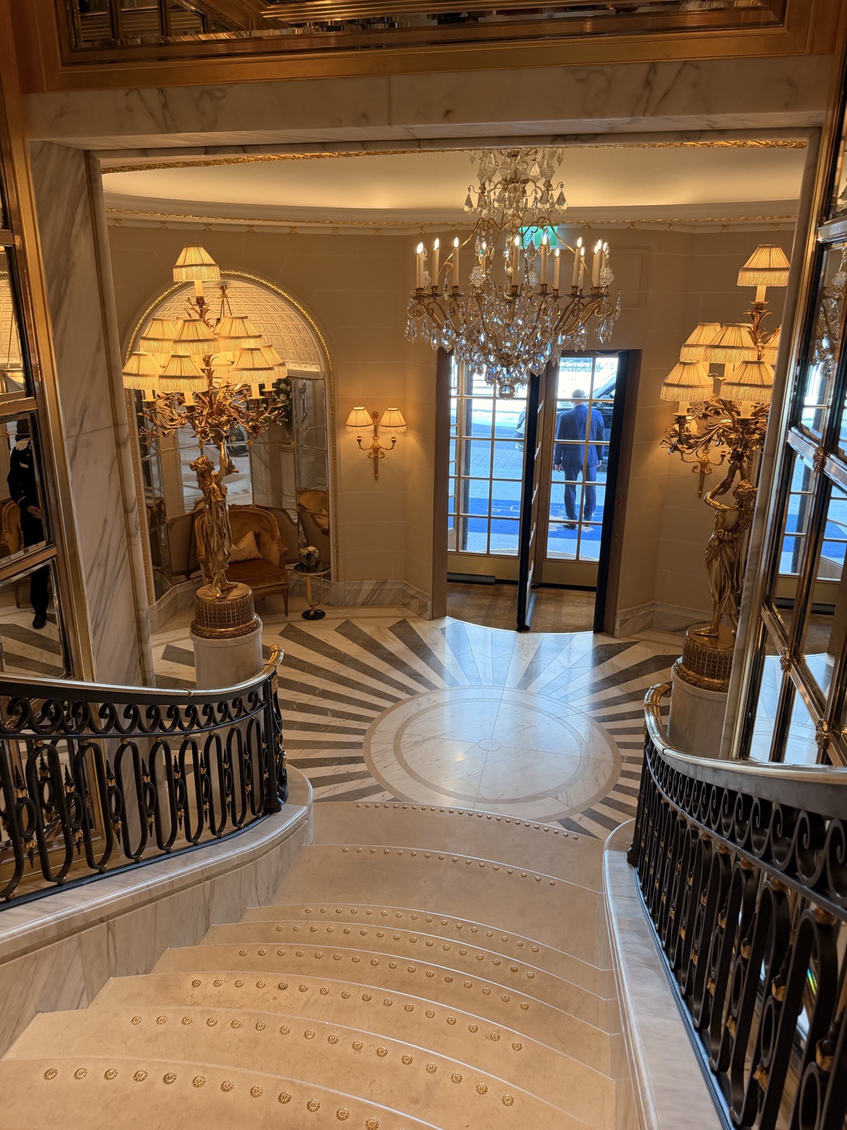 The gilded entrance hall of The Ritz London after its refurbishment, with chandeliers and mirrored panels