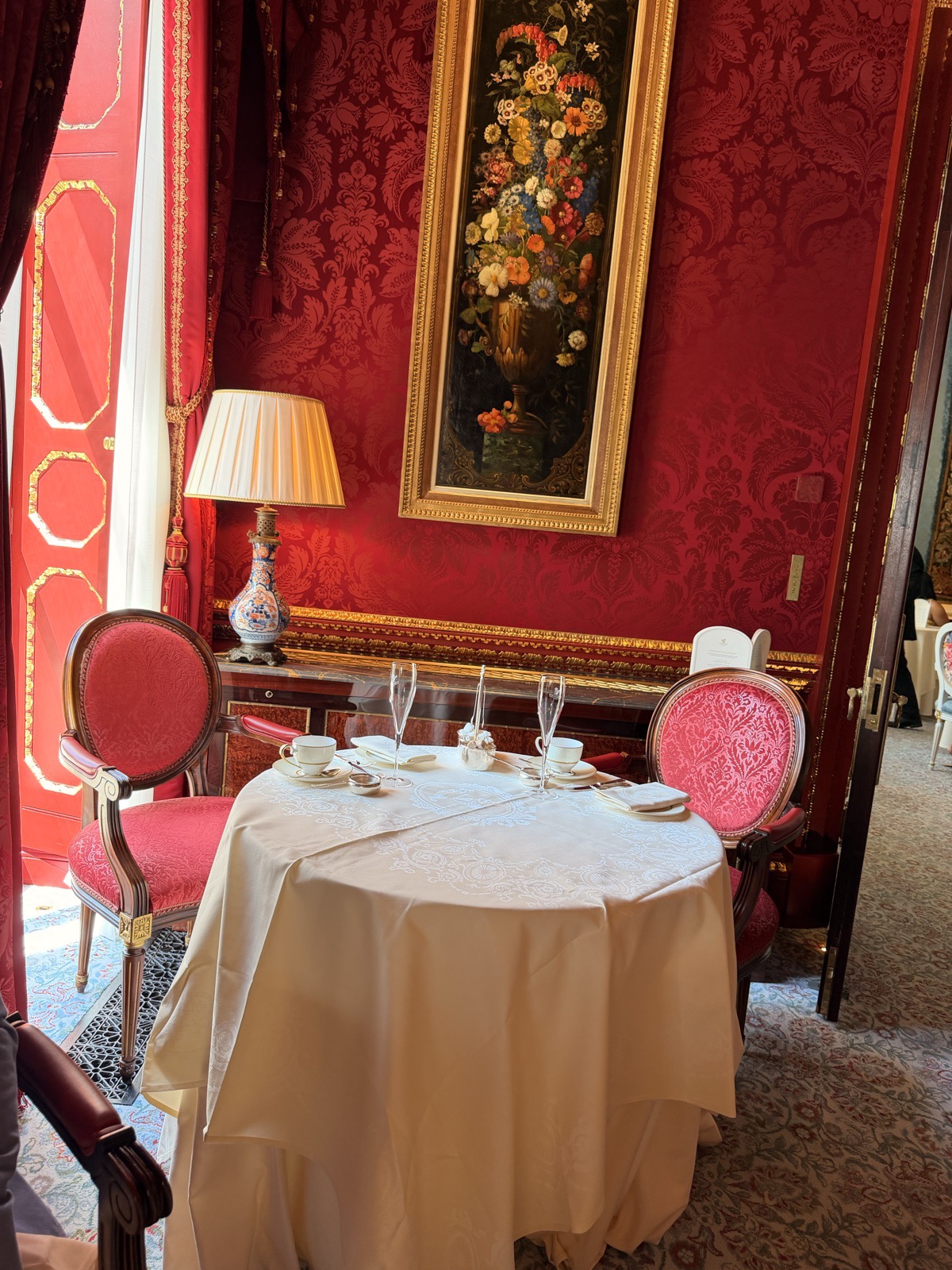 An afternoon tea table at The Ritz London set with cream linen, silver cutlery and Ritz branded china