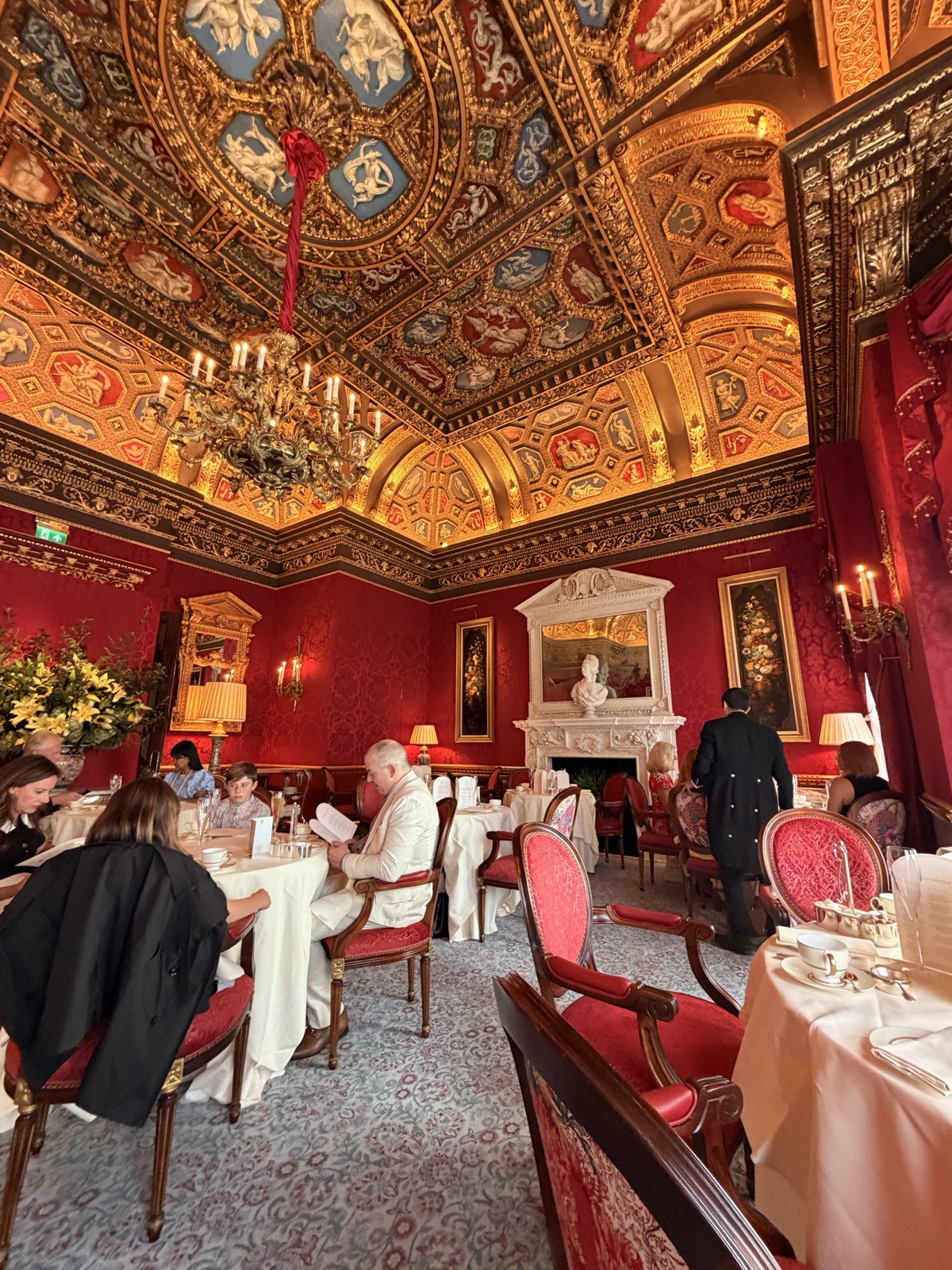 Afternoon tea at The Ritz London served in William Kent House, with crimson damask walls and a gilded painted ceiling