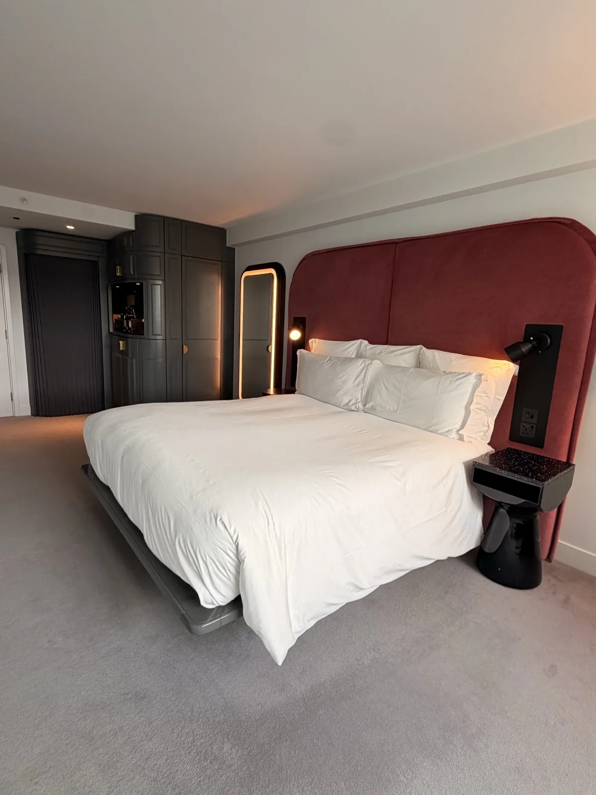 The extra large bed at Sea Containers London against its curved burgundy velvet headboard