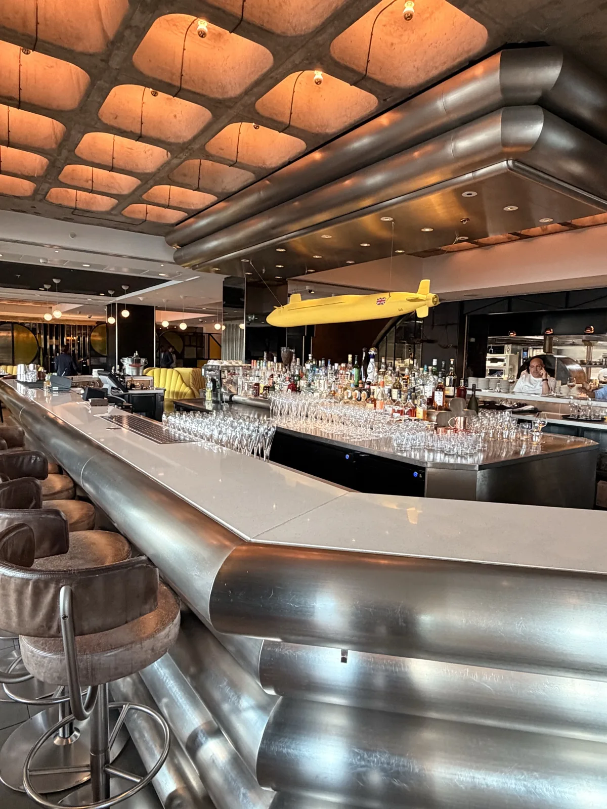 The Sea Containers Restaurant bar on the ground floor, a sweep of brushed steel under a lit coffered ceiling, facing the Thames path