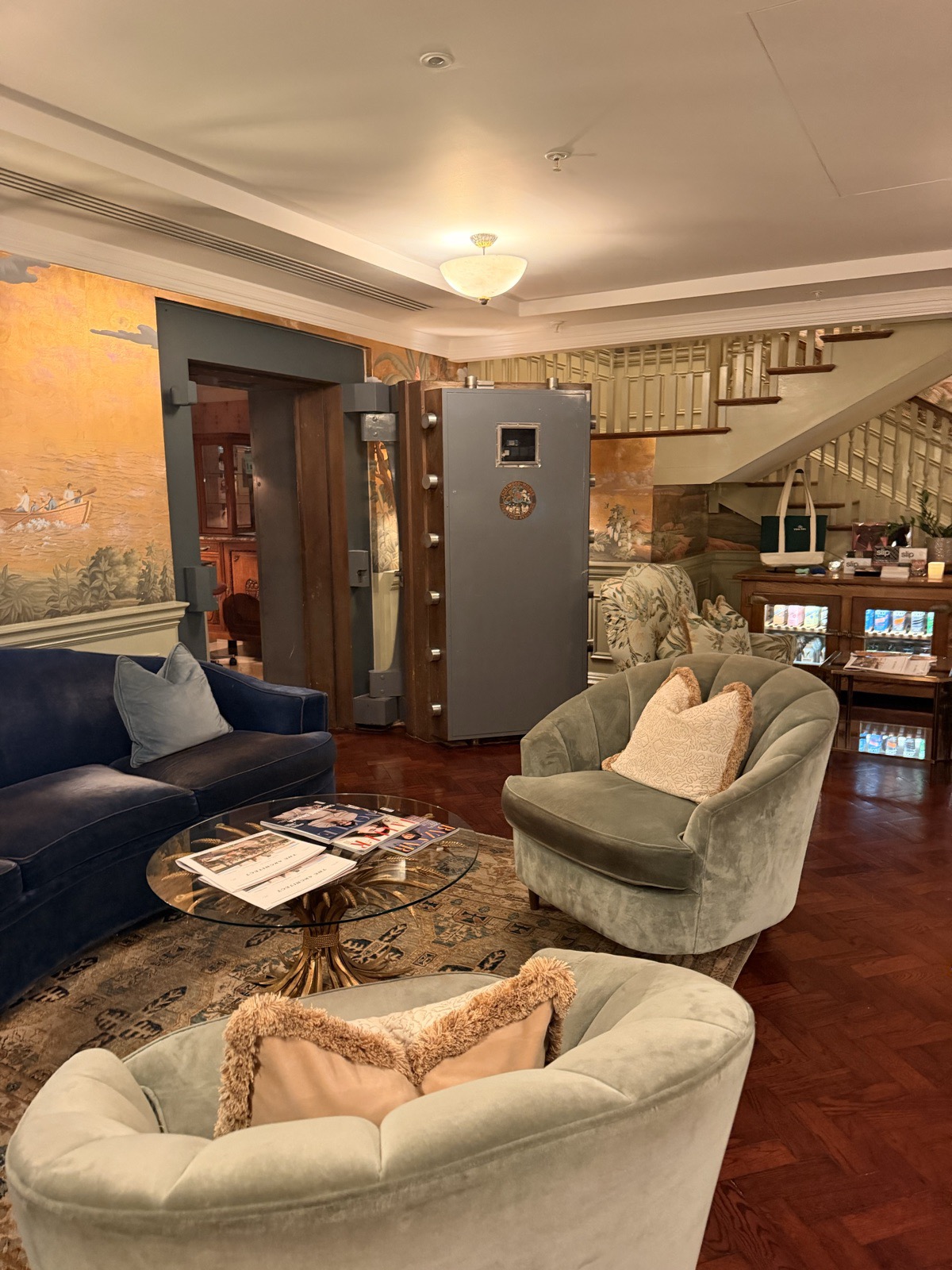 The lounge at Ned's Club Spa, with velvet armchairs beside an original bank safe