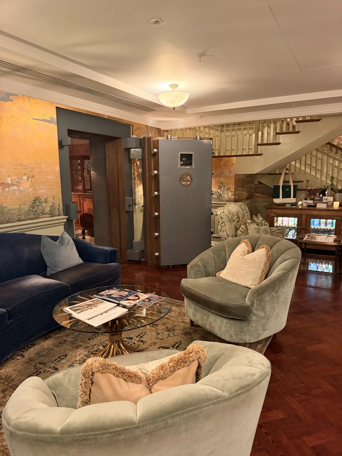 The lounge at Ned's Club Spa, with velvet armchairs beside an original bank safe