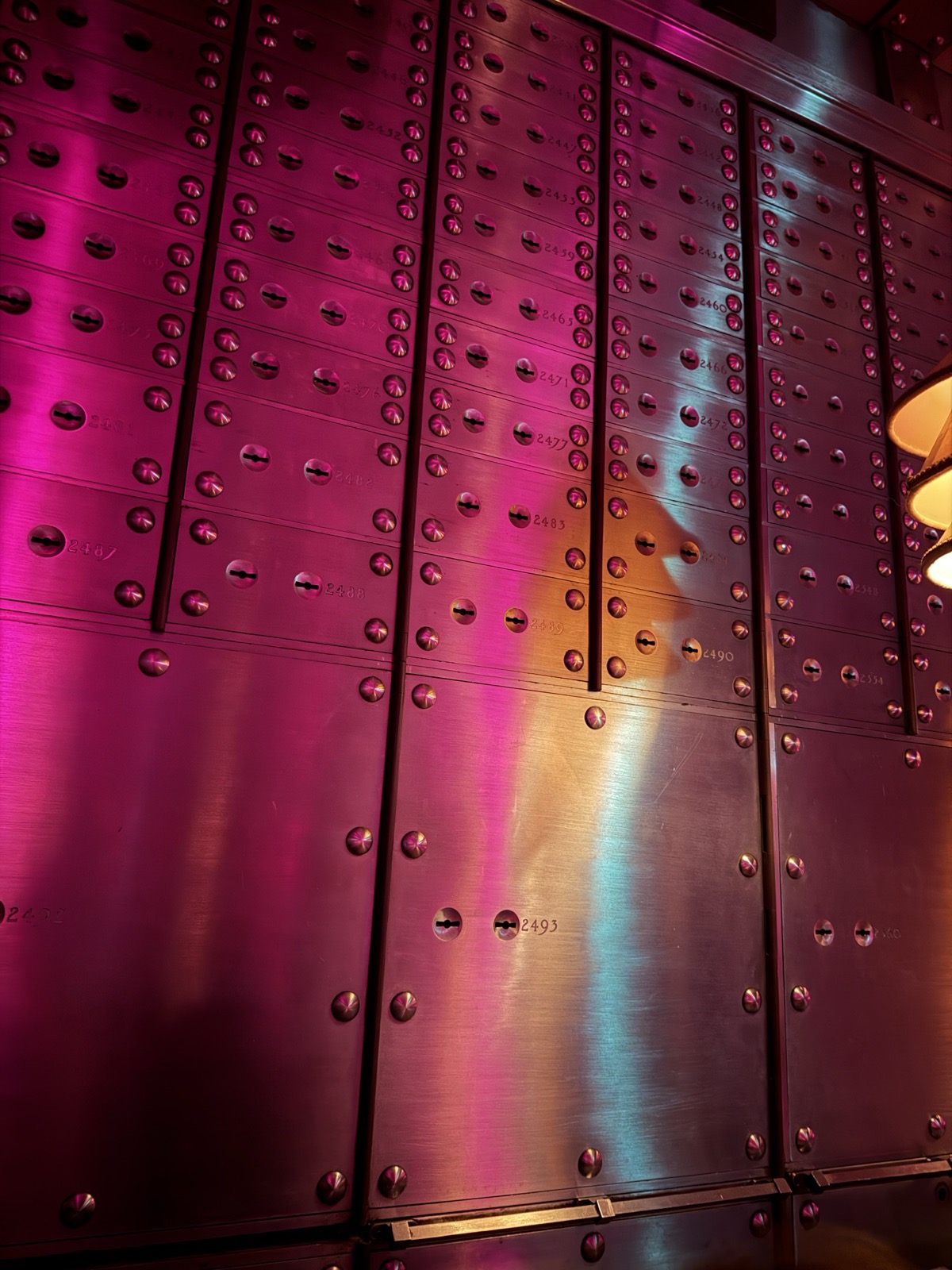 A wall of original hand engraved silver safety deposit boxes in the Vault at The Ned