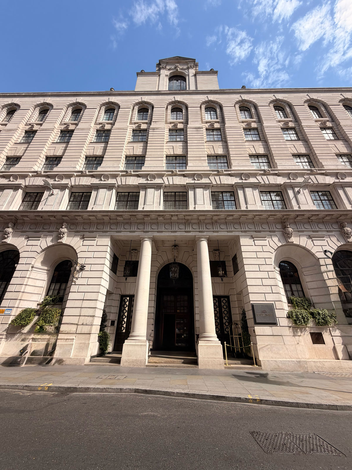 The entrance to The Ned on Poultry, where the doorman meets arriving guests and taxis pull up to the front